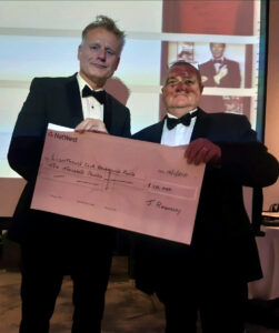 Two men holding up a large cheque