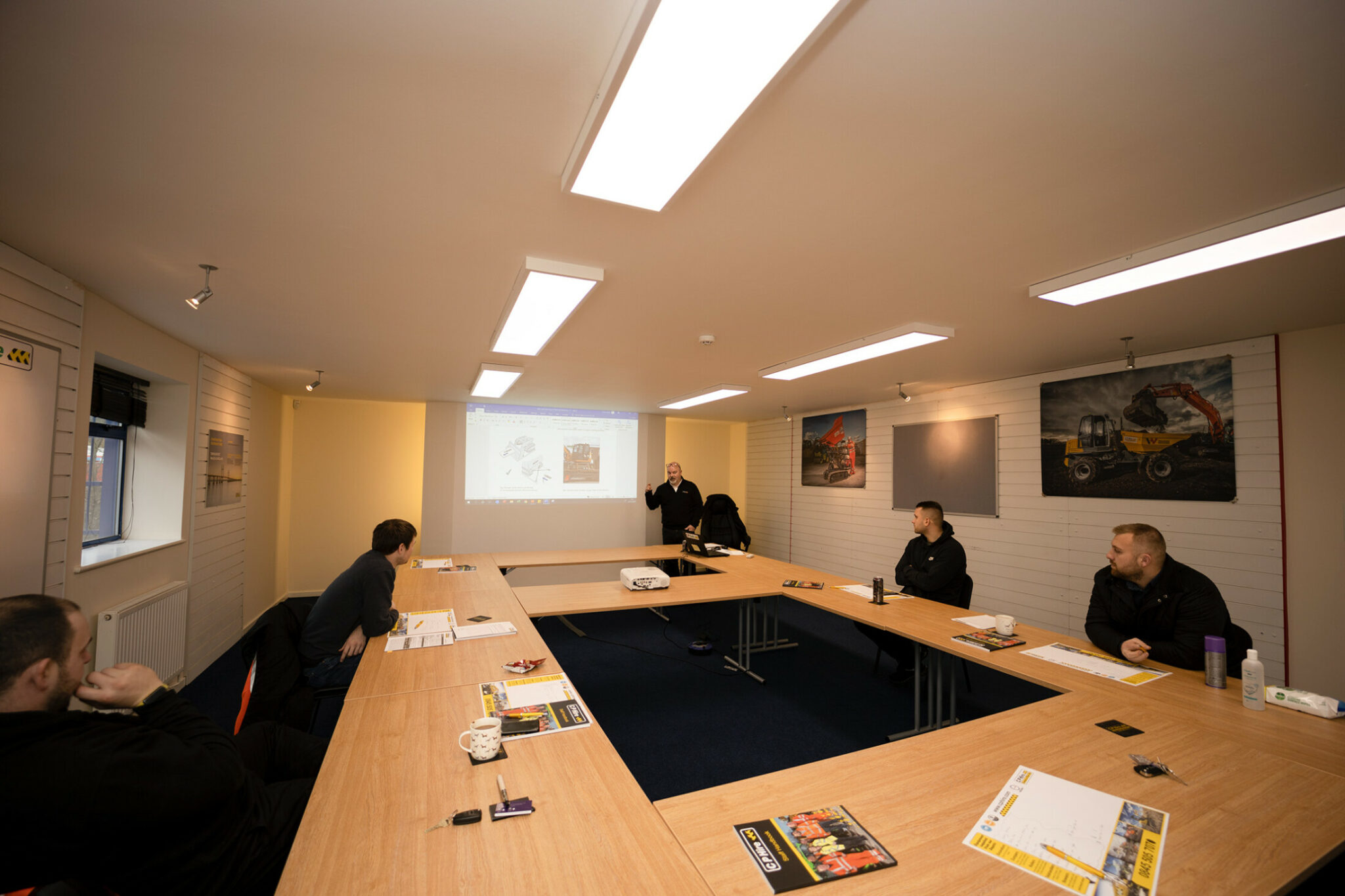 Wide-angle shot of a boardroom meeting with projector