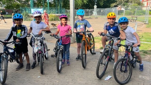 Children stood next to their bikes in a playground